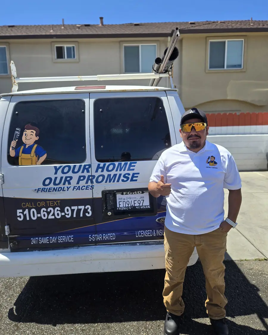 Friendly Services plumber next to a company van that reads Your Home, Our Promise