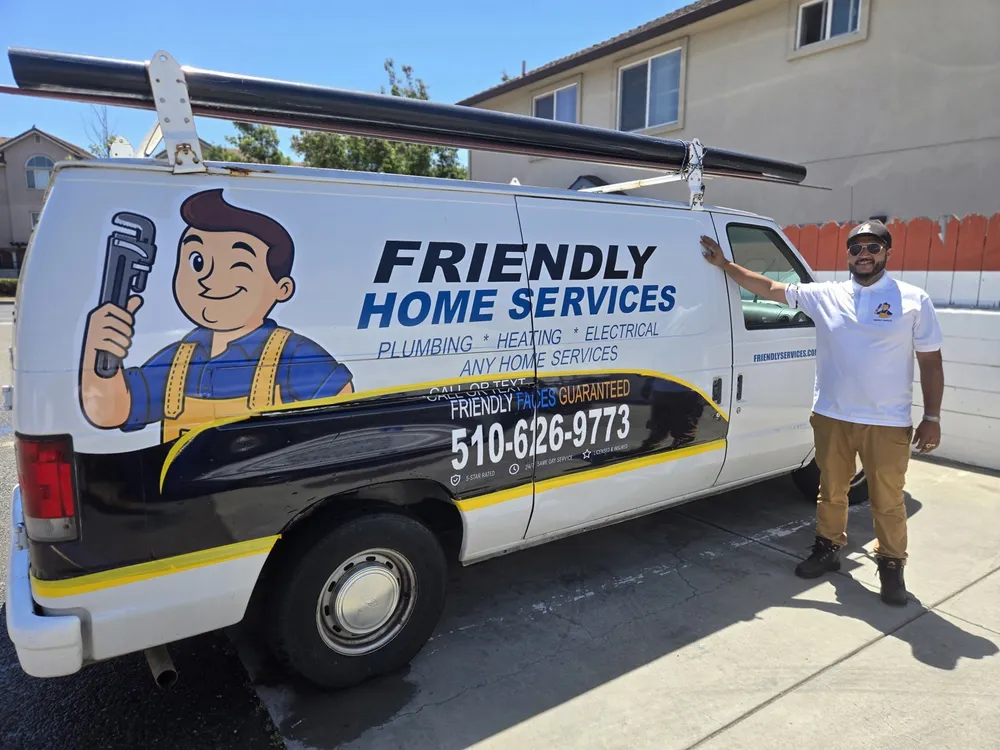 Friendly Services plumber next to a branded company van