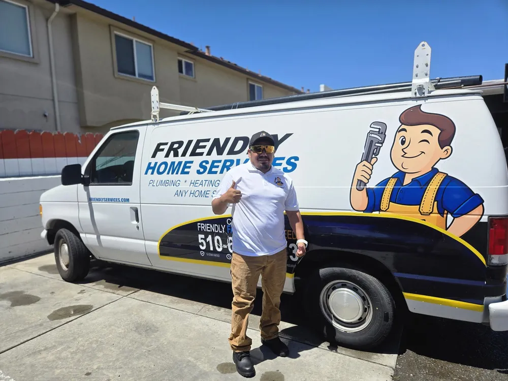 Friendly Services plumber giving a thumbs up next to the company van