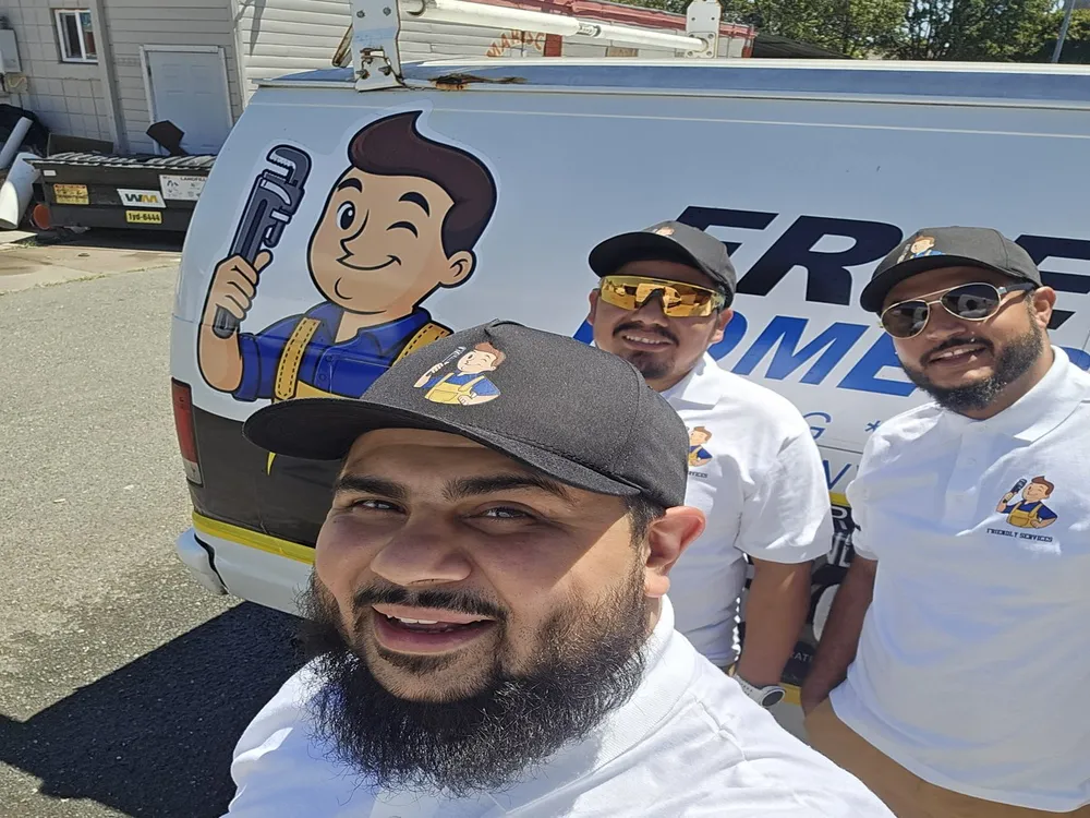 Ahmad, Elias and Robby of Friendly Services in front of a company van